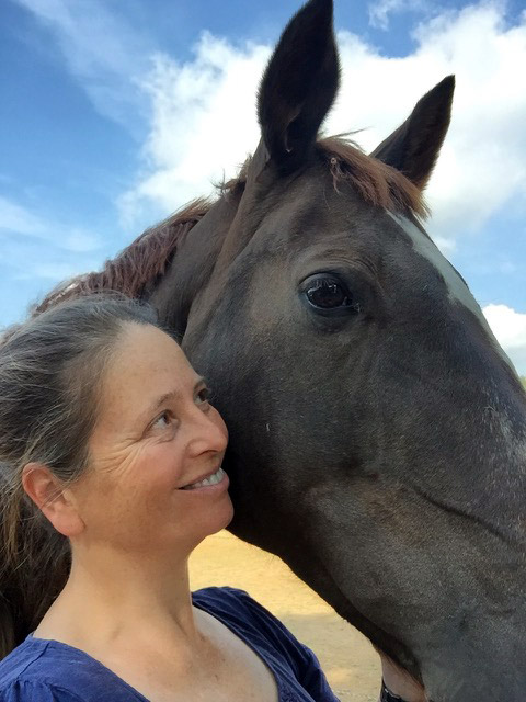 Kate smiling with a black horse