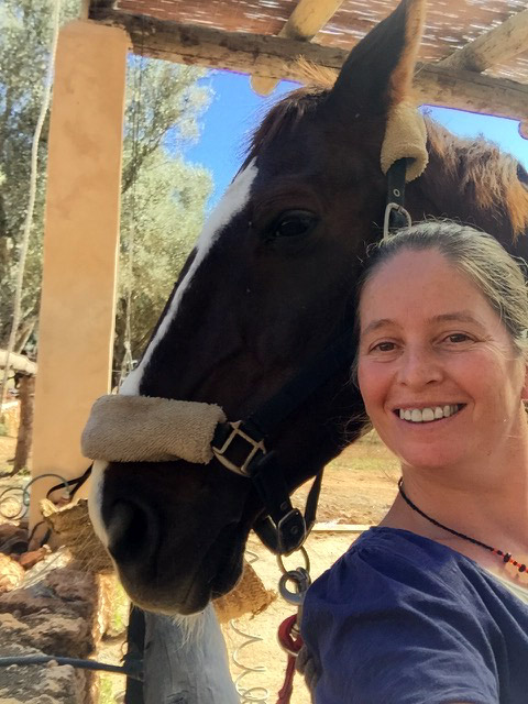 Kate smiling with a black horse